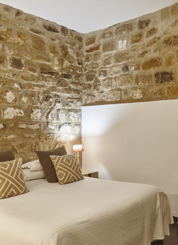 bedroom-with-stone-walls-comfortable-modern-hotel-room-interior-architecture.jpg
